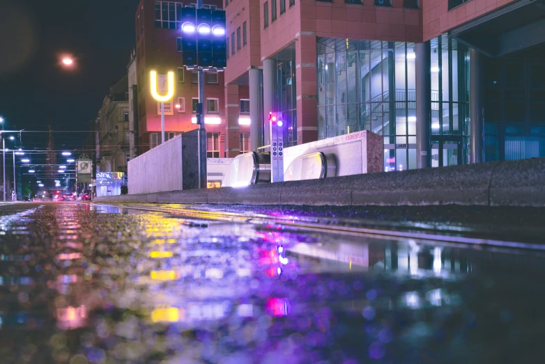 there is a very dark street with rain in the ground