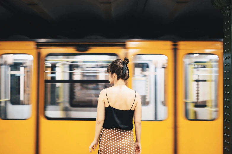 a woman waiting at a train station in an old fashion