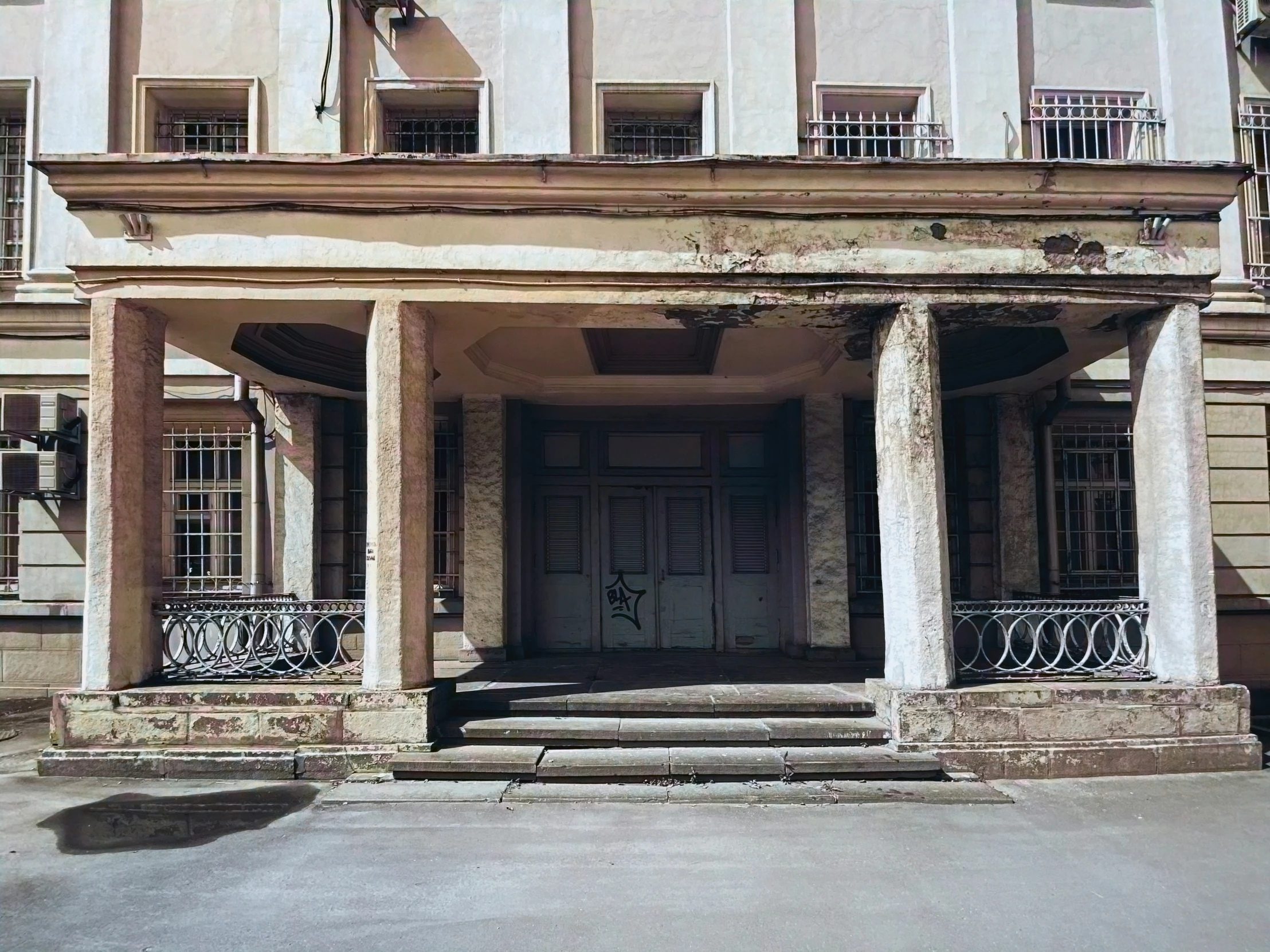 an old style building with columns and windows on the first story