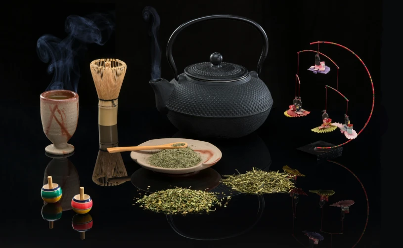 some tea and herbs on a black table