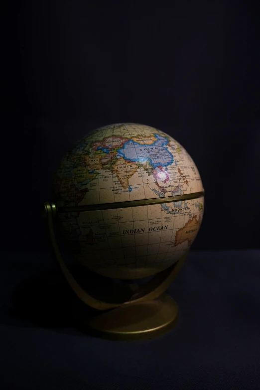 a globe with a pole in front of a dark background