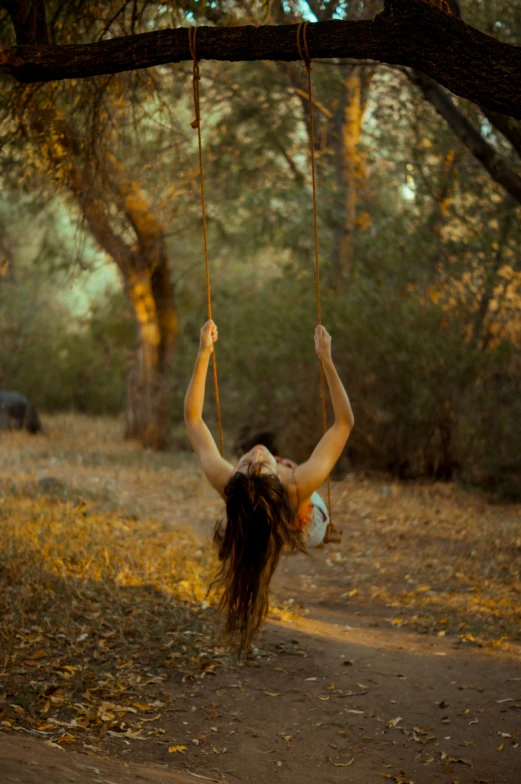 a woman is swinging on a rope swing