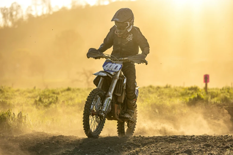 a dirt biker with helmet, riding on his bike