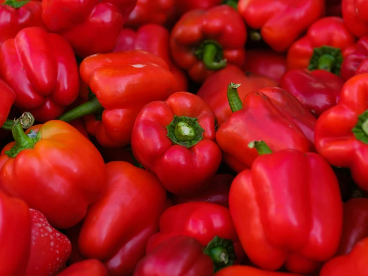 red peppers with green tops are in rows