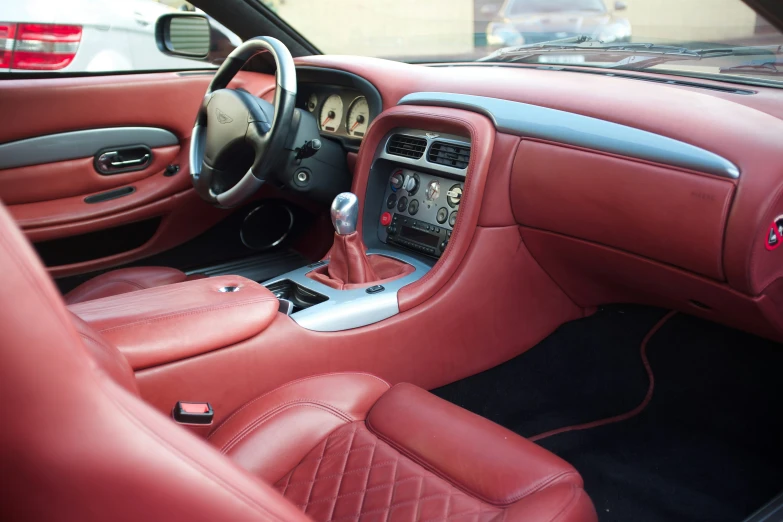 the interior of a red sports car with the passenger door partially open