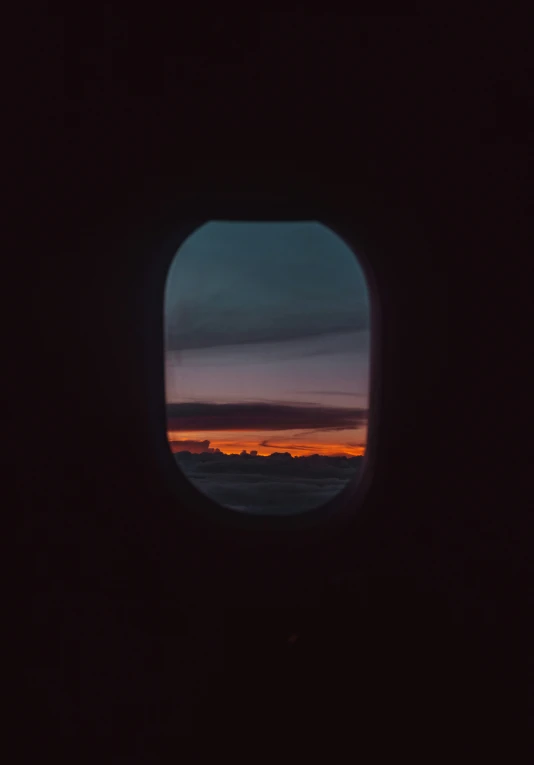 an airplane window showing the view of a sunset