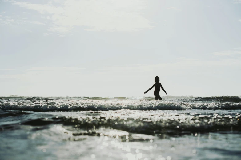 man surfing across the ocean waves on his board