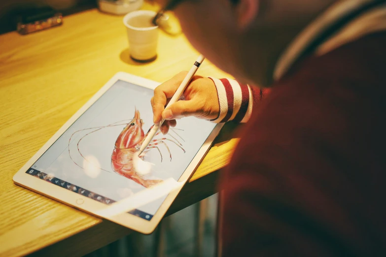 a person is painting with an ipad on a table