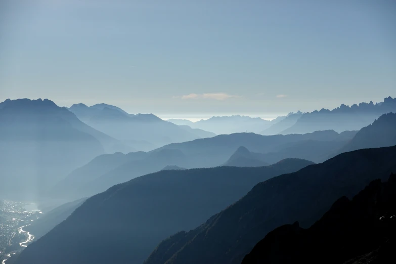 the sky is over some mountains, with a body of water in the middle