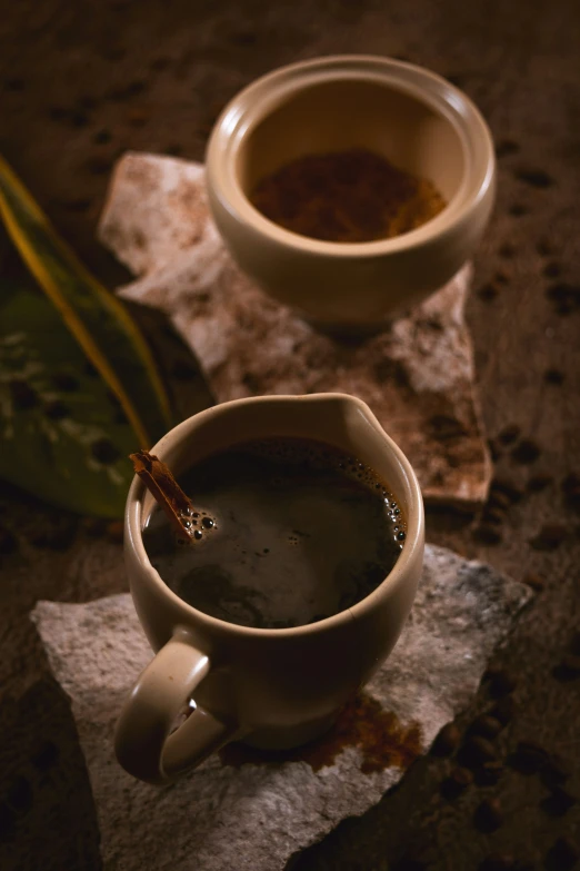 a white cup sitting next to a mug of tea