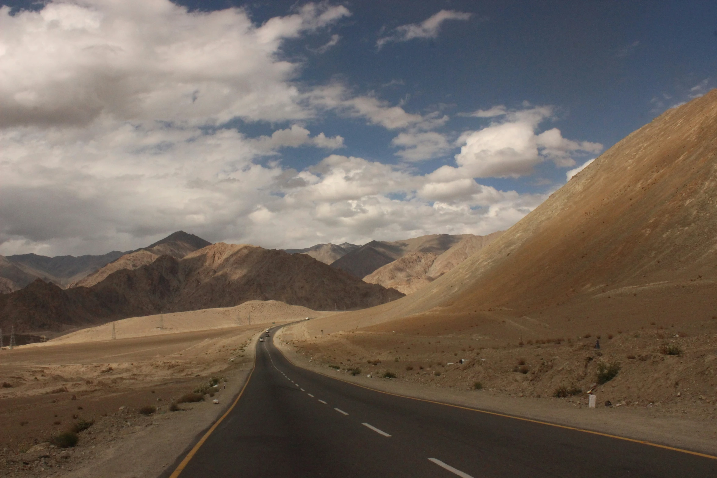 the highway winds through desert terrain towards mountains