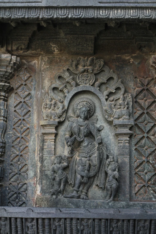 an ancient carving depicting hindu deities, a demon and the sun