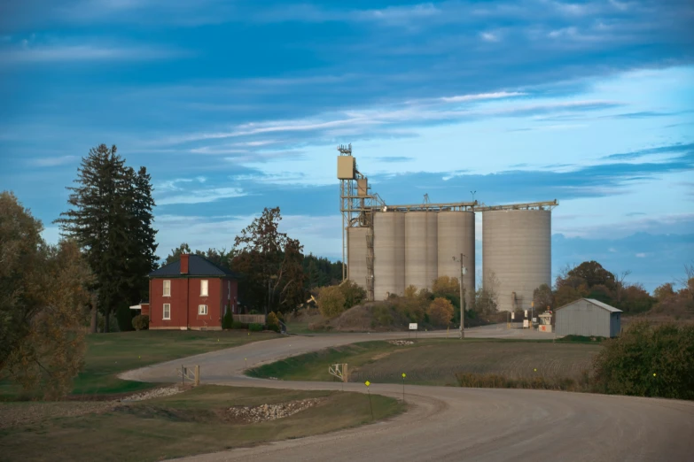 a large grain silo next to a road in the country