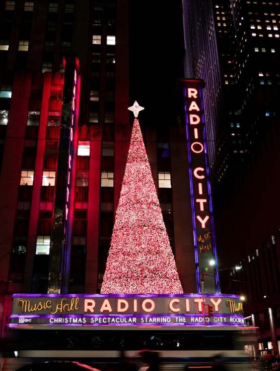 a radio city christmas tree is lit up at night