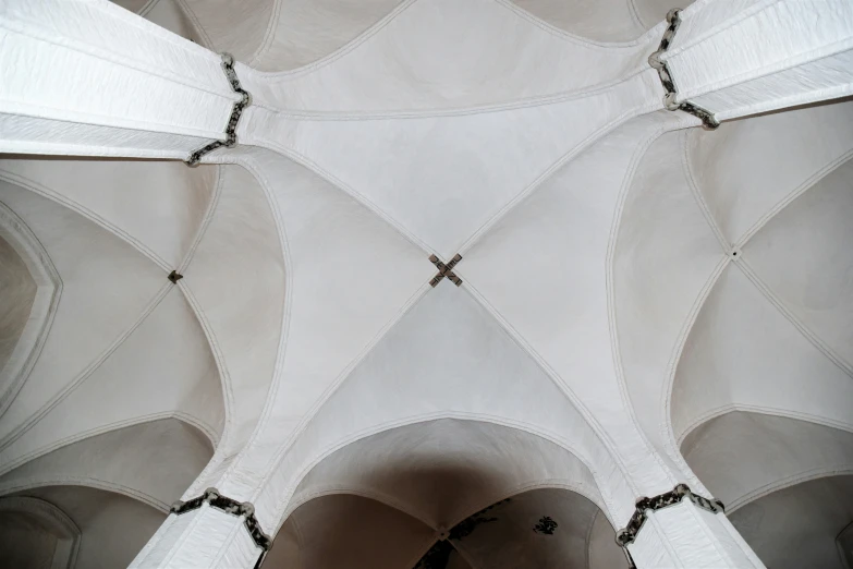 some pillars in a church and the ceiling has white walls