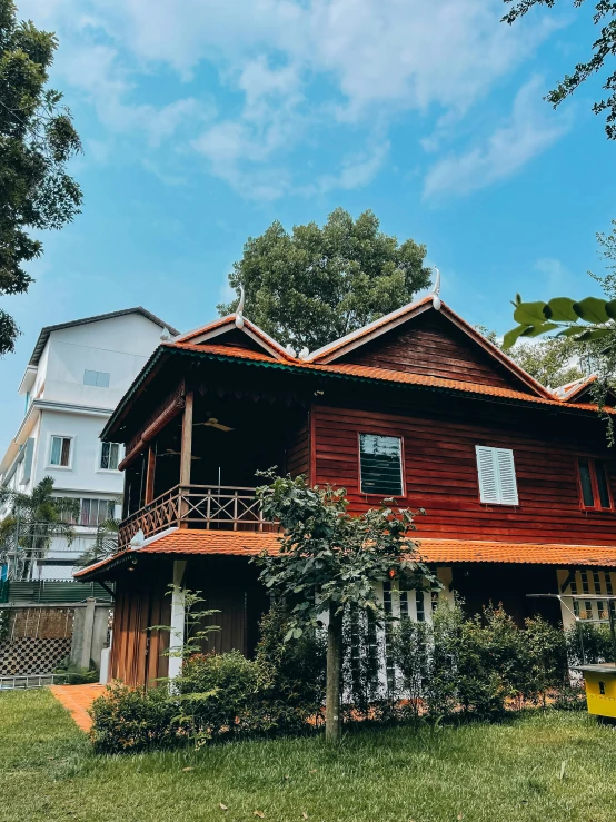 large wooden house surrounded by trees on top of a grassy hill