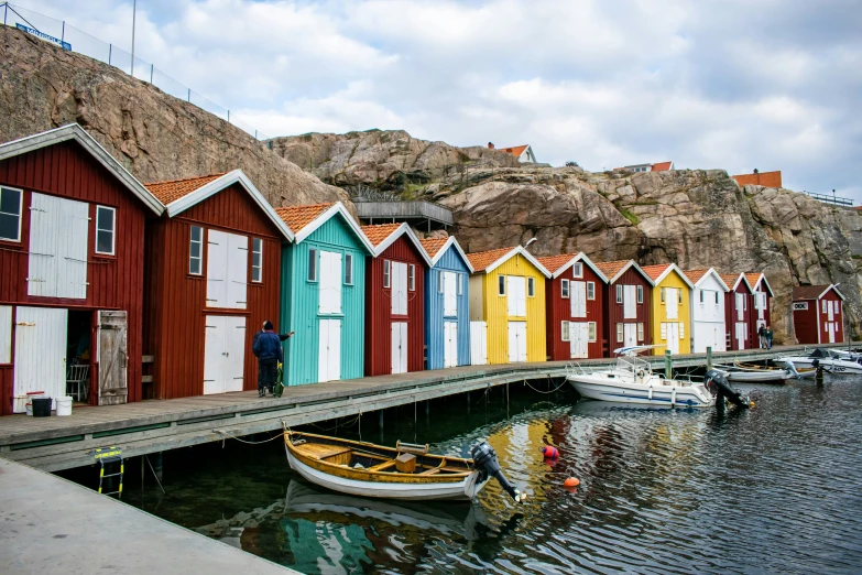 many colorful beach huts sit along a river