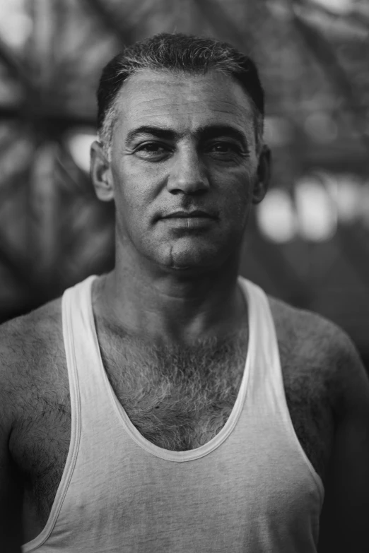 a man in a tank top poses for the camera