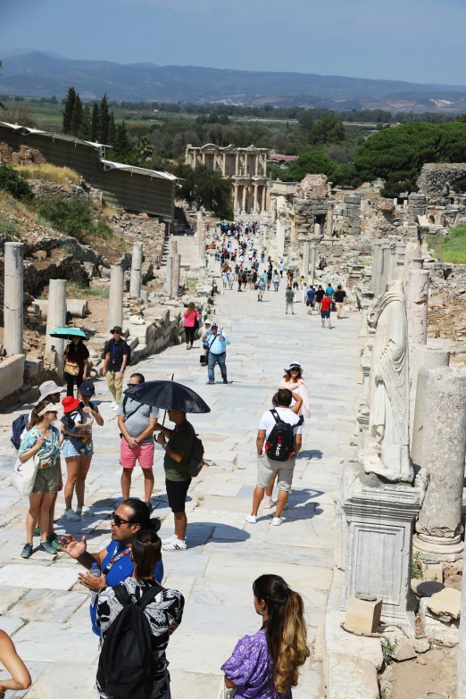 a crowd of people walking around a stone area