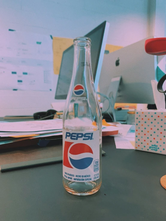 a soda bottle on a desk with a mouse