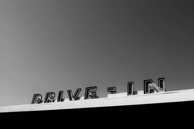 an airplane is flying over a sign on top of a building