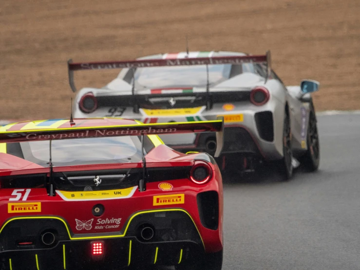 two racing cars race around the track