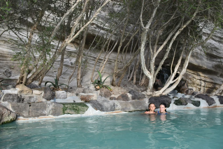 two people swimming in an artificial pool of water