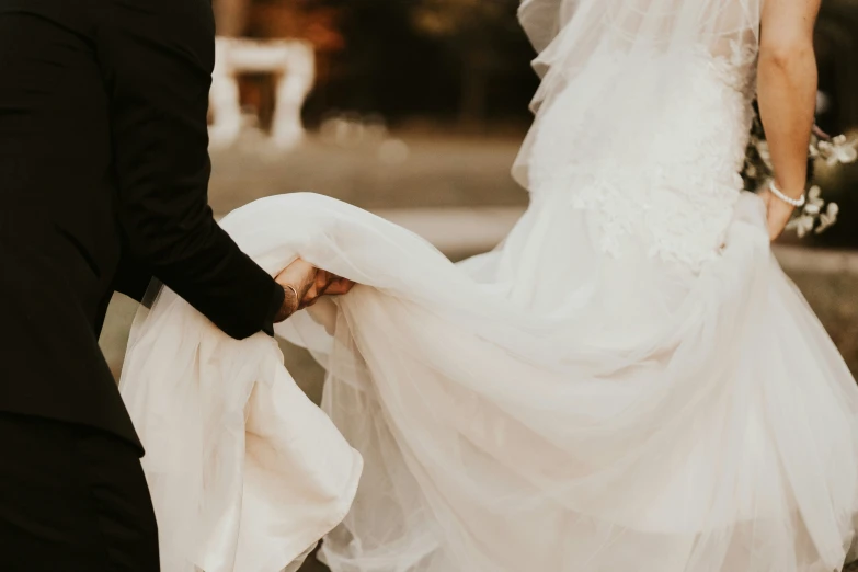 two people stand behind each other as they hold a dress