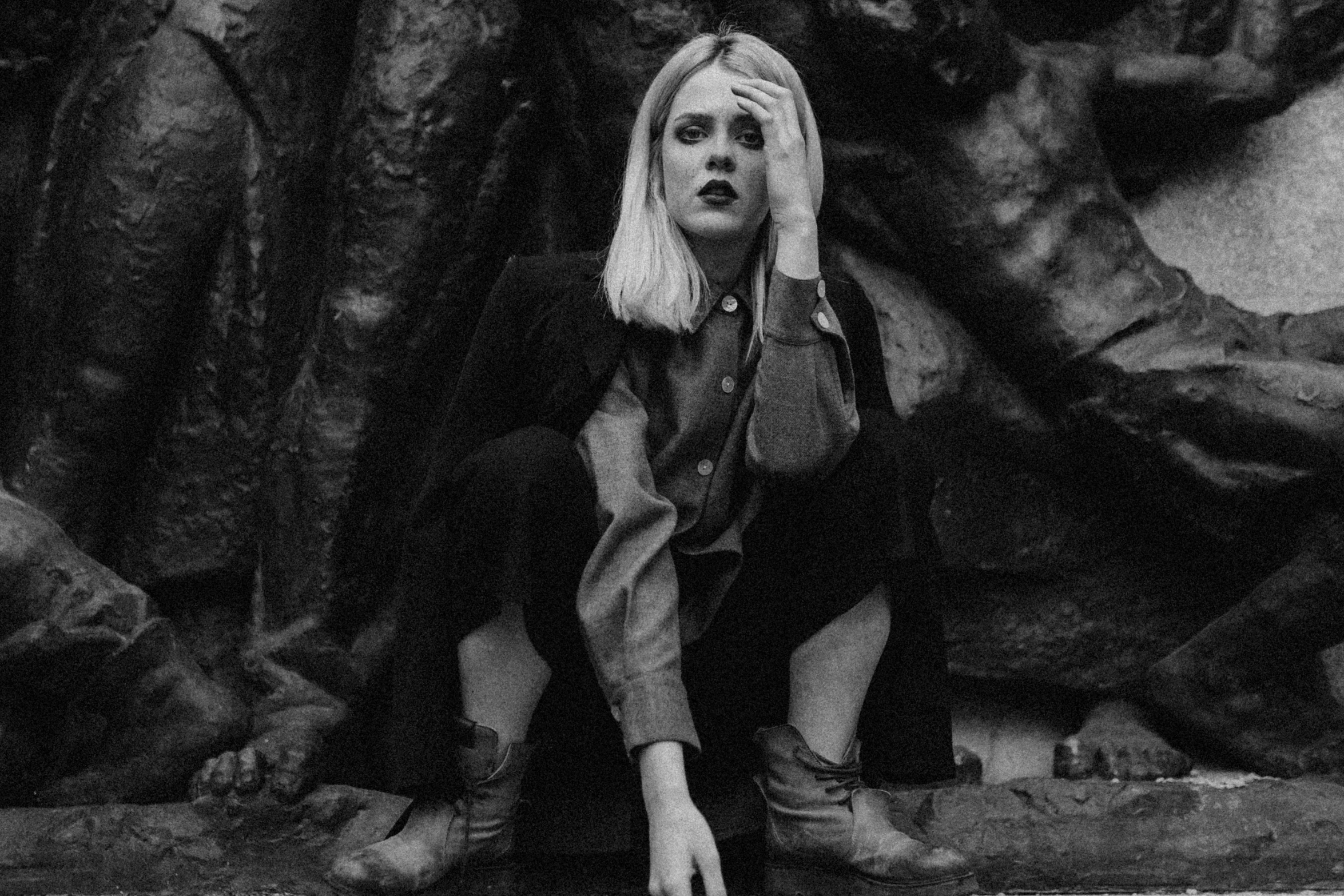 a young lady sitting on a rock posing for a pograph