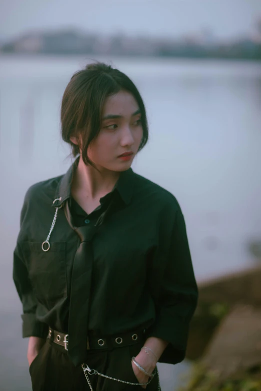 an asian woman standing in front of a body of water