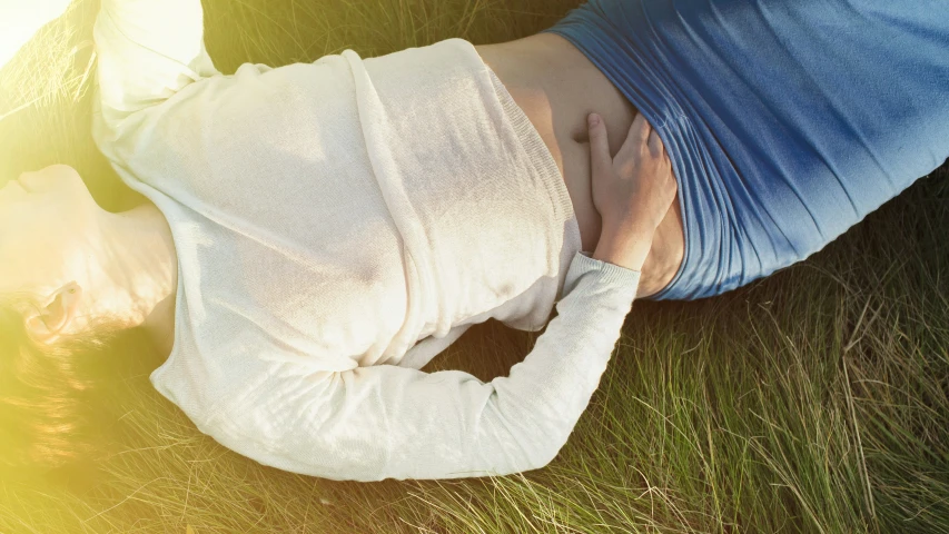 a person with bandages laying on the ground next to grass