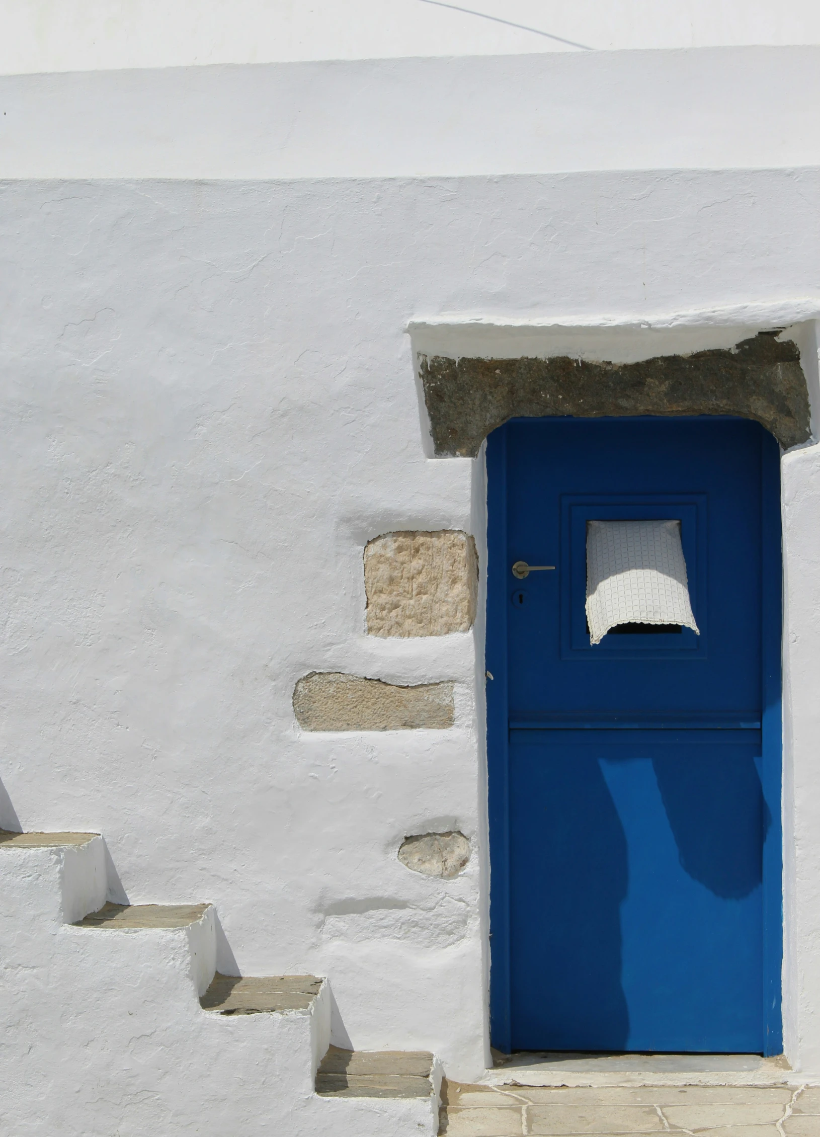 a bright blue door with stairs leading to it