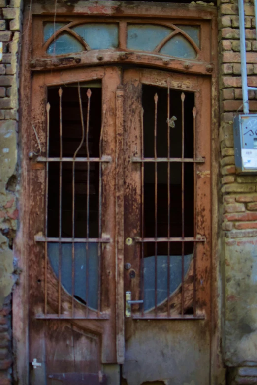 a rusted wooden door with bars on it
