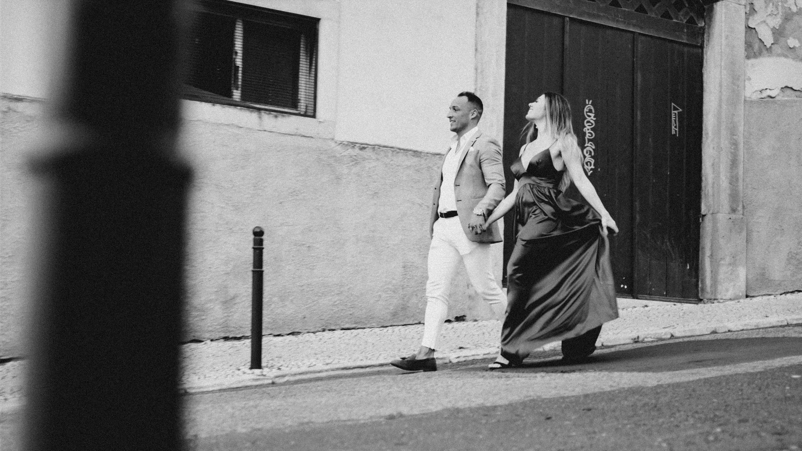 a woman in a long dress walking down the street