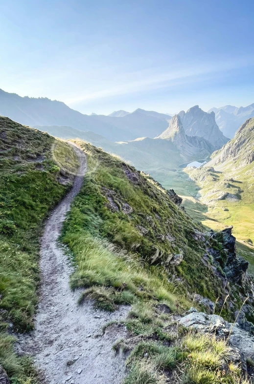 a trail going up the side of a grassy hill