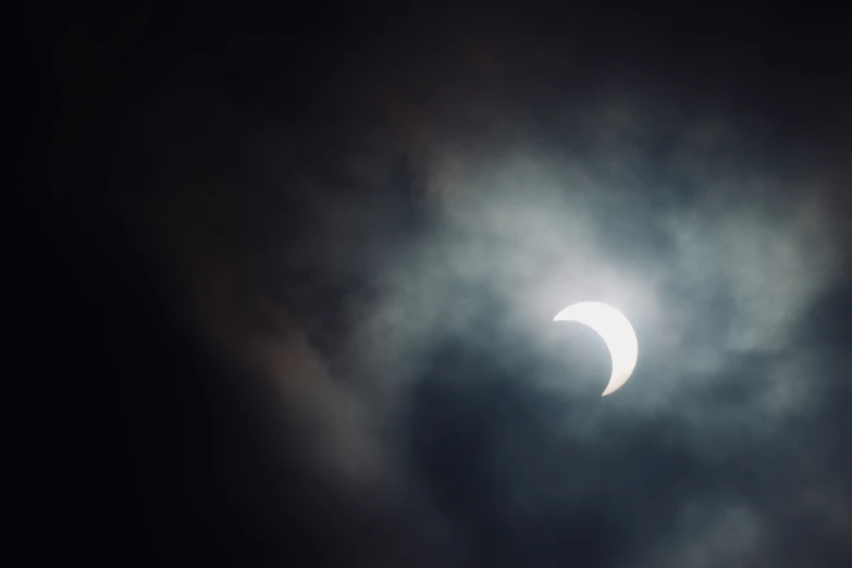 an image of a partial eclipse during a cloudy night