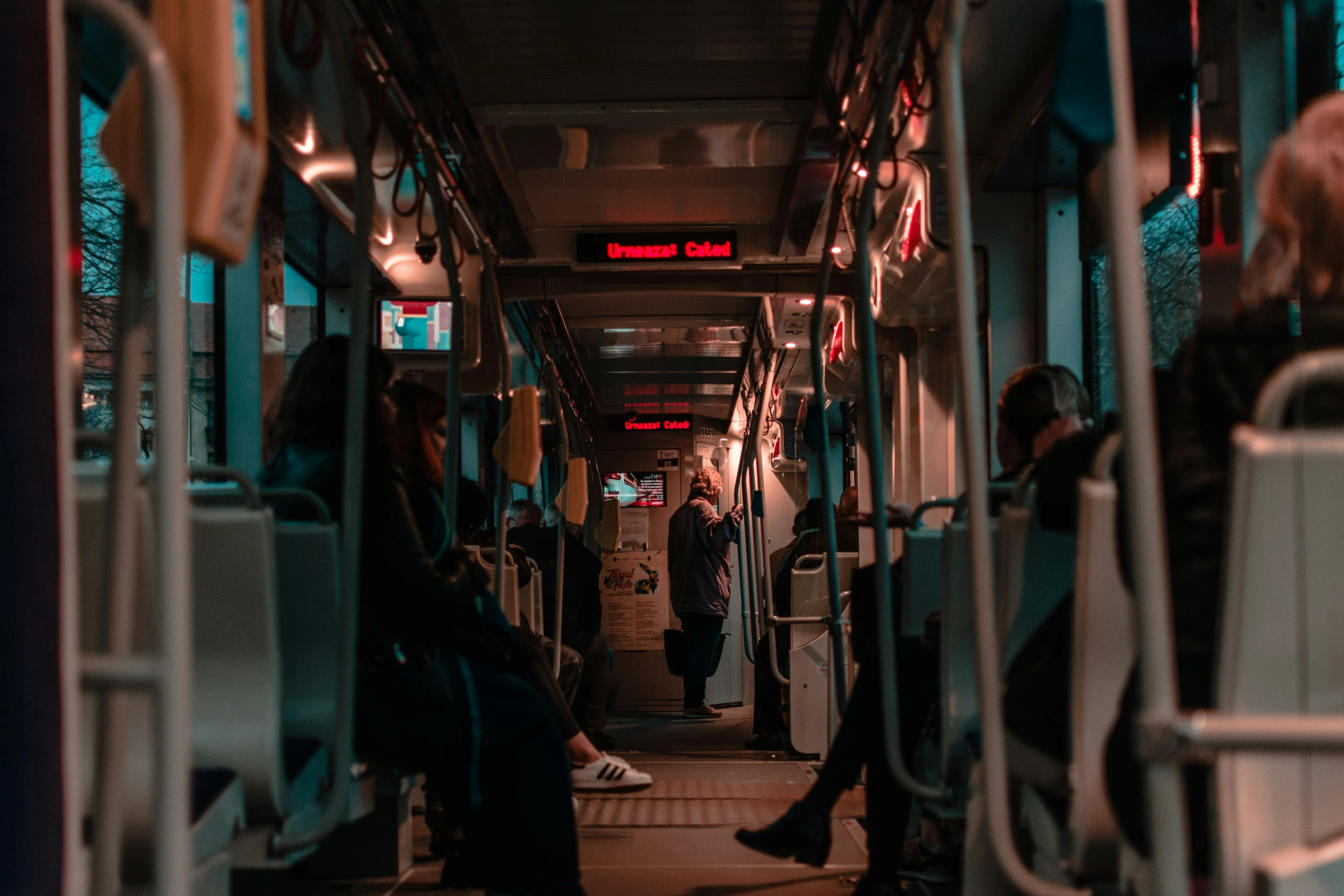 people sit and walk on an empty bus at night