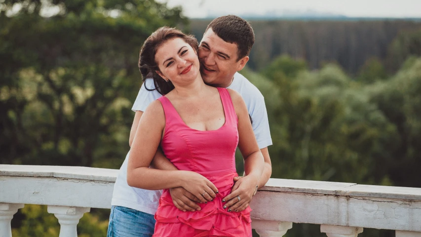 a man standing next to a woman on a bridge