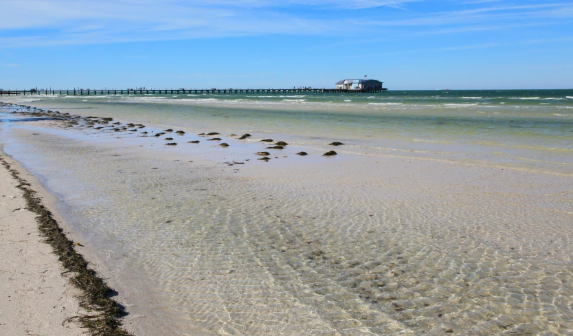 a beach has a long pier sticking out of the water