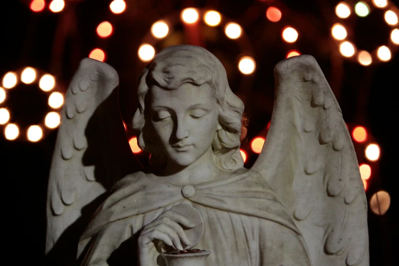 a close up view of an angel statue in front of a colorful display