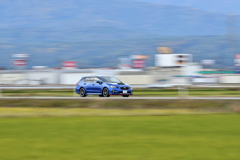 a blue car driving along a rural road