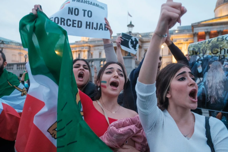 several people holding flags and signs protesting outside of a building