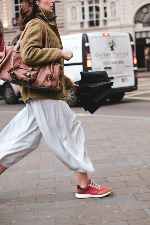 an older woman wearing a brown bag walking down the street