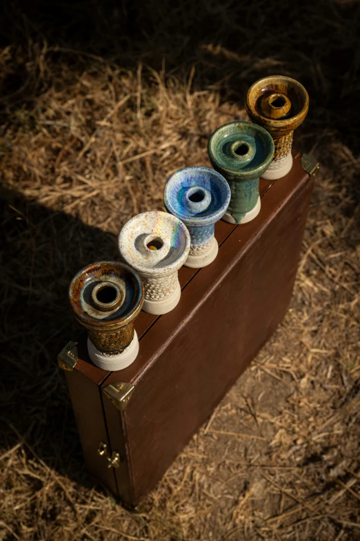 a brief case holding five spools of thread in it