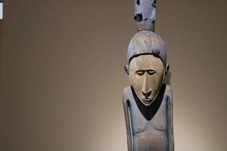 a carved wooden object with a decorative head