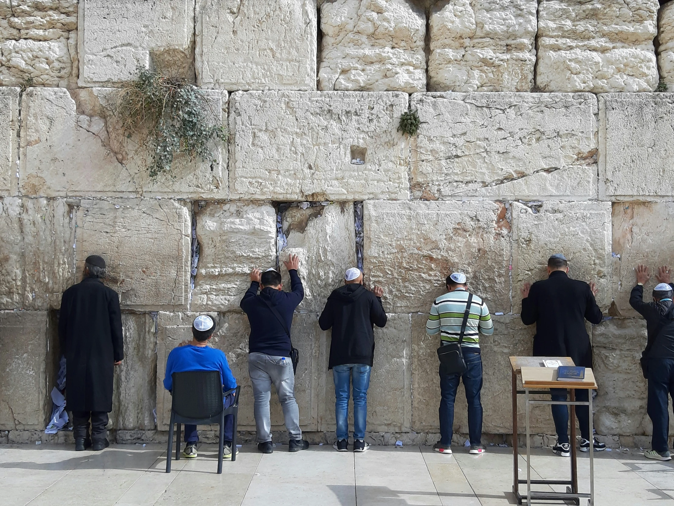 a group of men who are looking at a wall