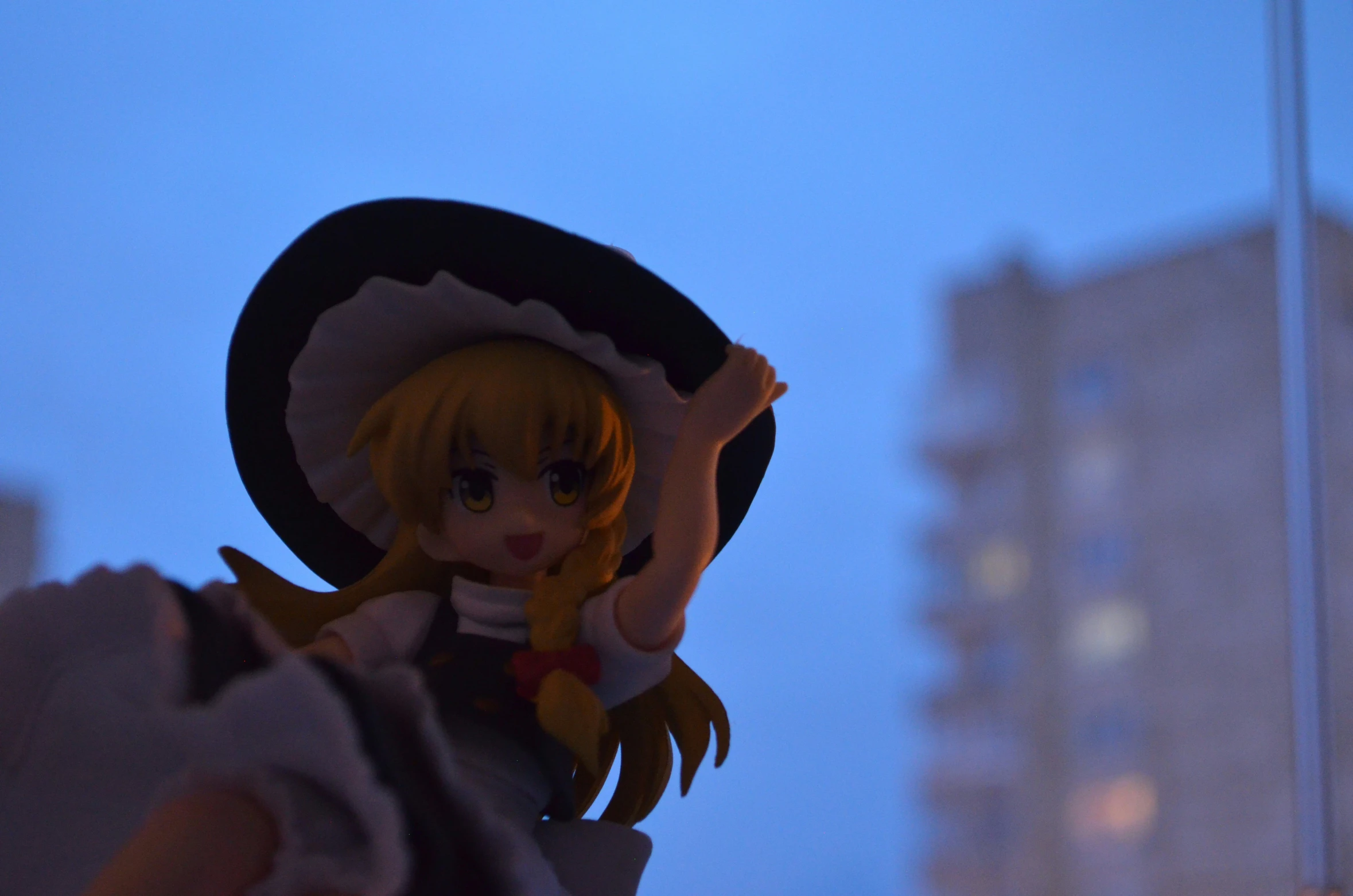 a doll stands next to buildings and street lights