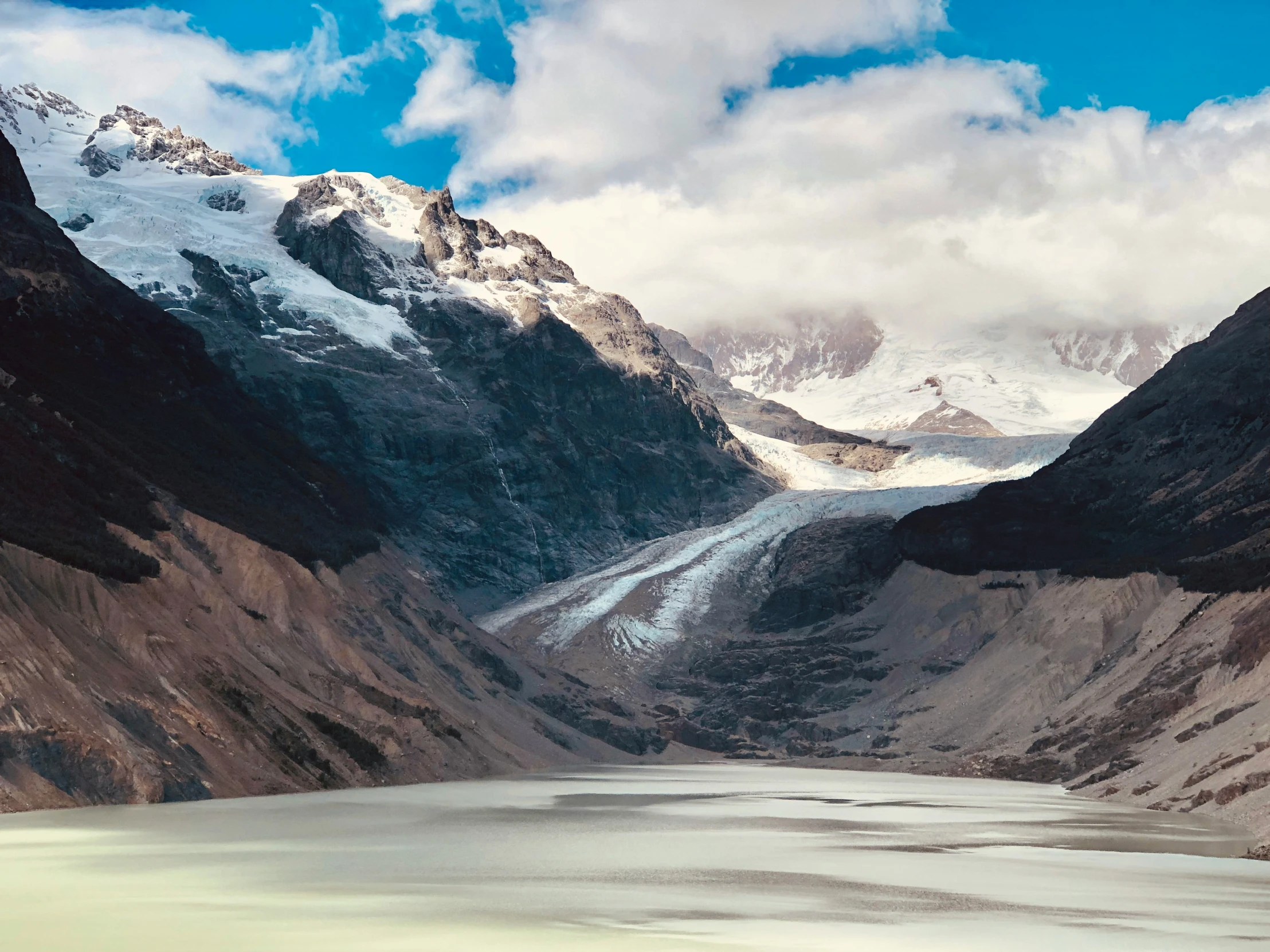 the mountain is covered in snow and has a large mountain range