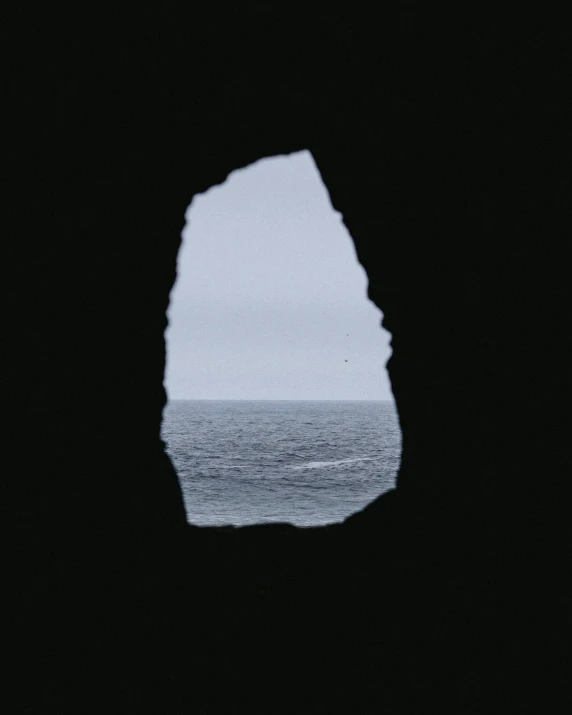 an ocean seen through the cave in the sand