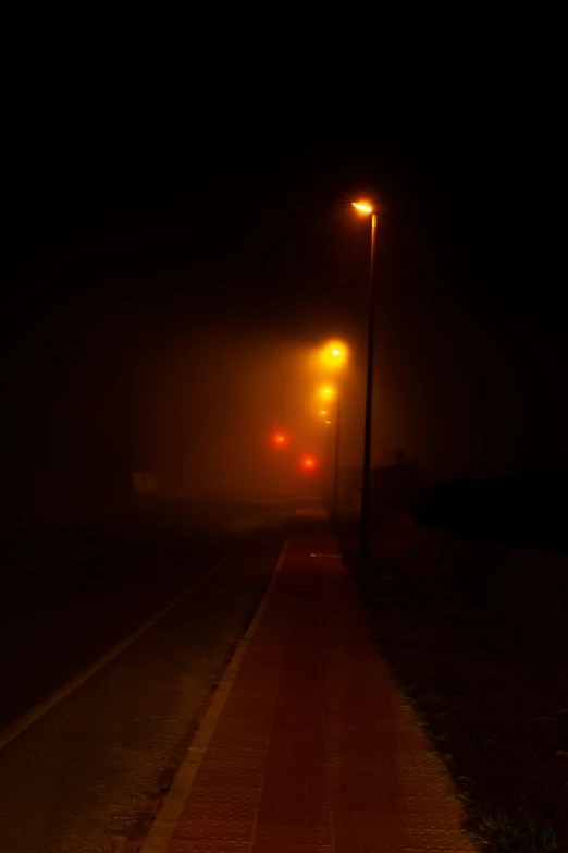 a foggy street at night on a dark street